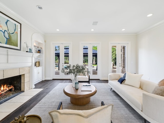 living room featuring french doors, ornamental molding, plenty of natural light, and a high end fireplace