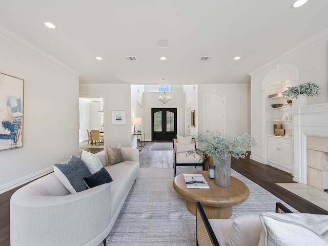 living room featuring dark wood-type flooring, ornamental molding, built in features, and french doors