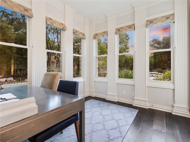 unfurnished sunroom with decorative columns