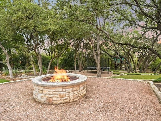 view of home's community featuring a playground, a trampoline, and an outdoor fire pit