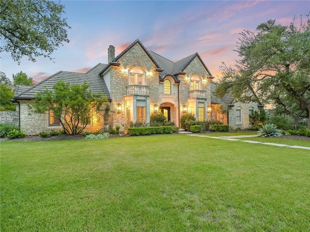 french country inspired facade with a yard