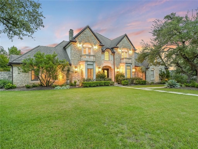 3844 Hunterwood Pt, Austin, TX 78746 - french country style house featuring stone siding, a chimney, and a front lawn