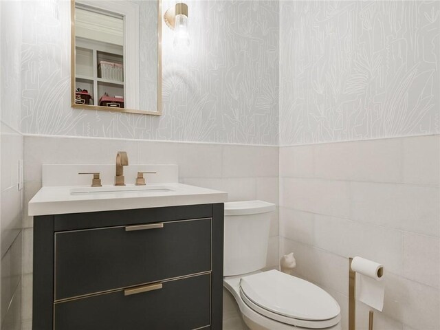 3844 Hunterwood Pt, Austin, TX 78746 - bathroom with wallpapered walls, tile walls, vanity, and wainscoting