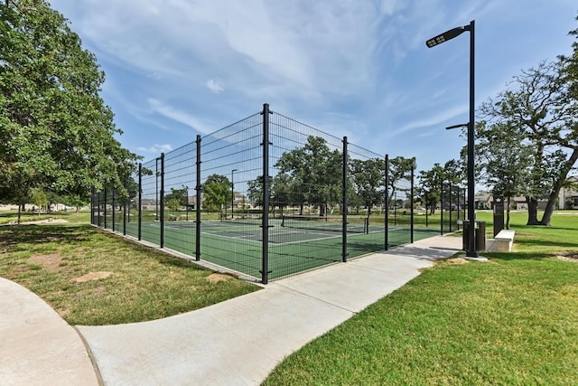 view of sport court with a lawn