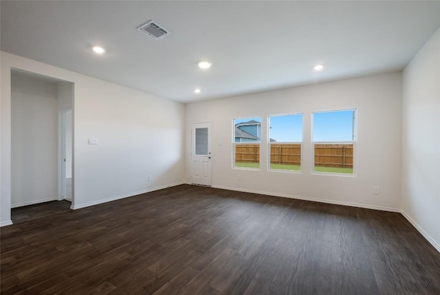 unfurnished room featuring baseboards, dark wood-style flooring, visible vents, and recessed lighting