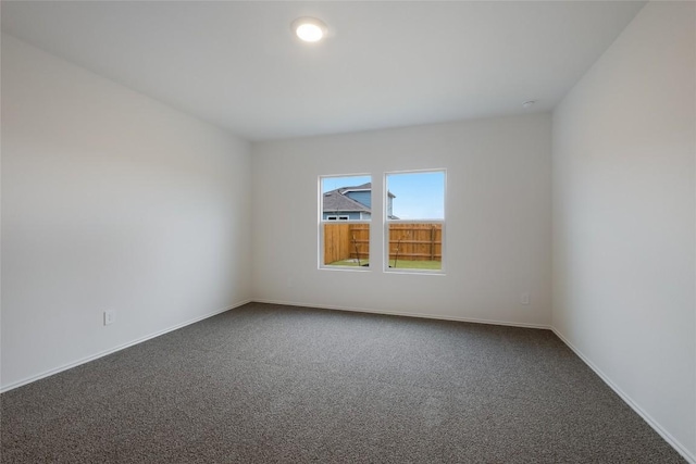 empty room featuring carpet floors and baseboards