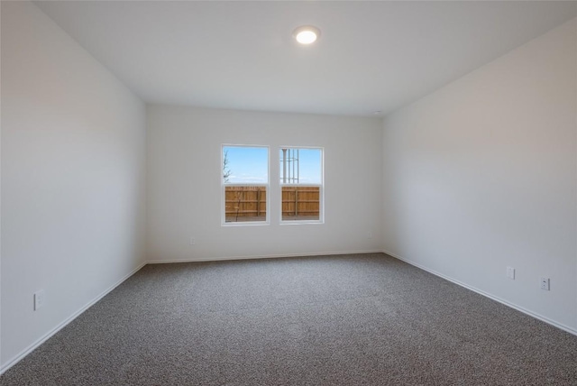 unfurnished room featuring carpet floors and baseboards