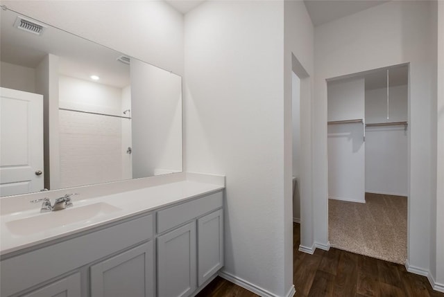 bathroom with baseboards, visible vents, wood finished floors, and vanity