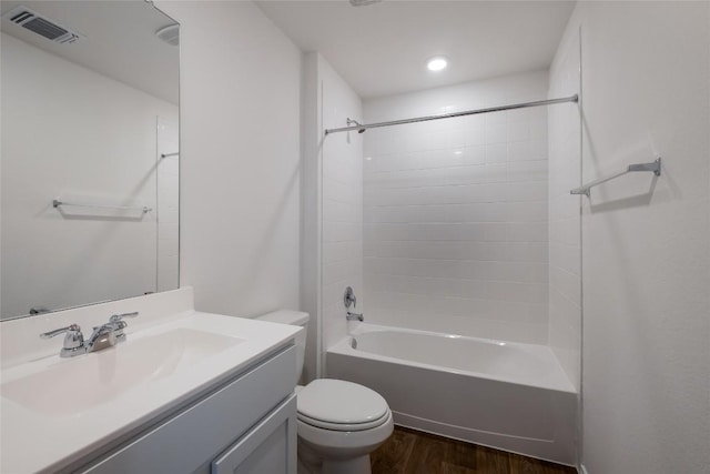 bathroom featuring visible vents, toilet, wood finished floors, bathtub / shower combination, and vanity