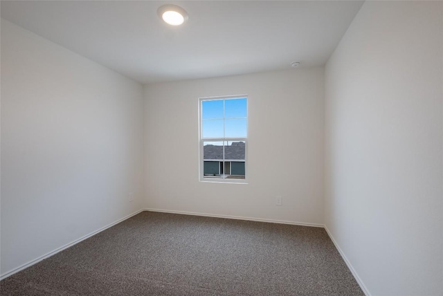 carpeted spare room featuring baseboards