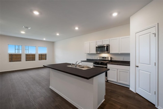 kitchen with visible vents, dark countertops, appliances with stainless steel finishes, dark wood-style flooring, and a sink