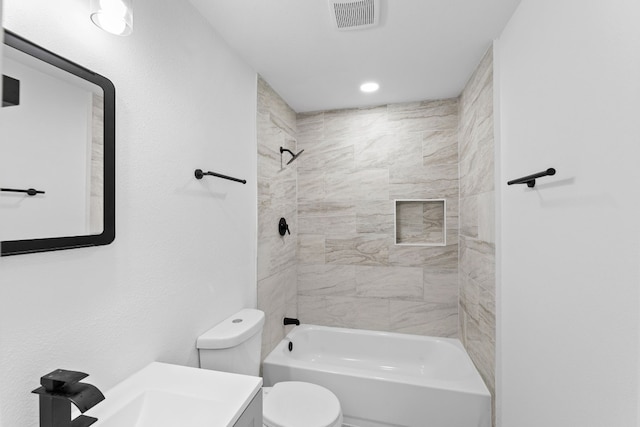 full bathroom with vanity, tiled shower / bath combo, and toilet