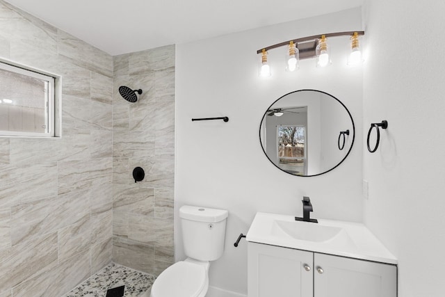 bathroom with vanity, a tile shower, and toilet