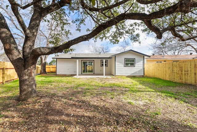 rear view of house featuring a lawn and a patio area