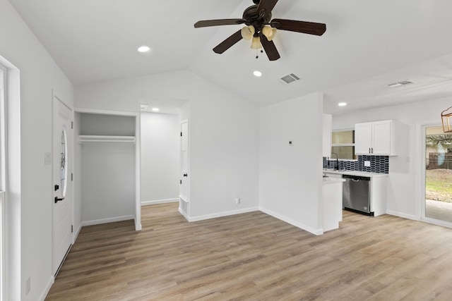 unfurnished living room featuring ceiling fan, lofted ceiling, sink, and light hardwood / wood-style floors