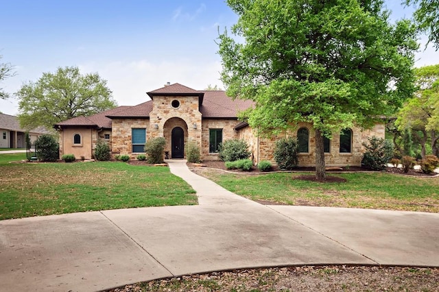 1782 Running Creek Dr, Salado, TX 76571 - mediterranean / spanish home featuring stone siding, roof with shingles, and a front yard