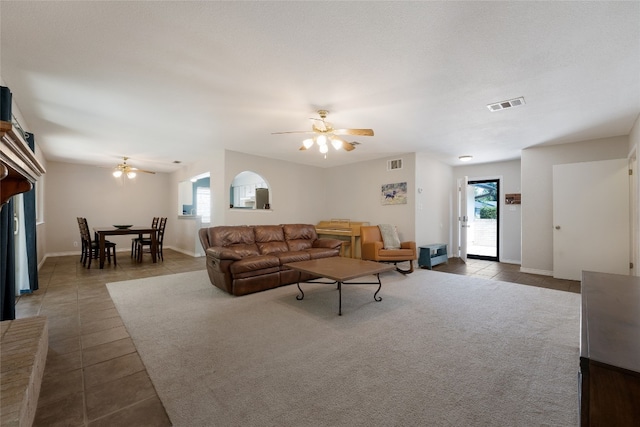 living room with a healthy amount of sunlight, dark tile patterned flooring, and ceiling fan