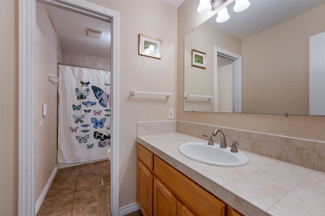 bathroom with a shower with curtain, vanity, toilet, and tile patterned flooring