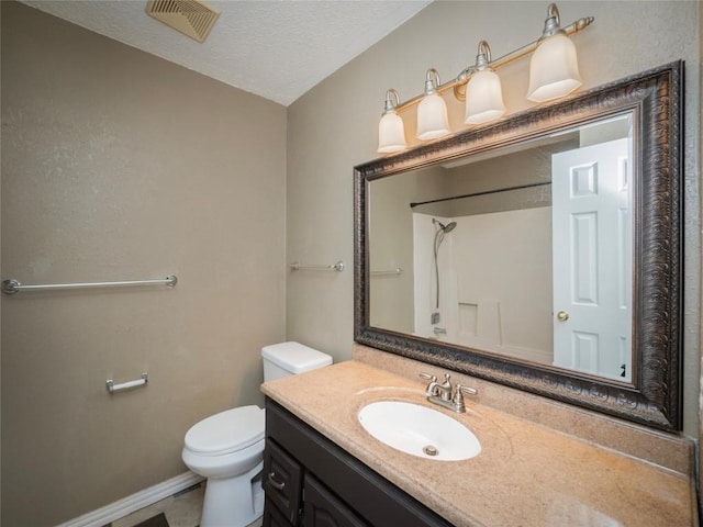 bathroom featuring vanity, a textured ceiling, toilet, and walk in shower