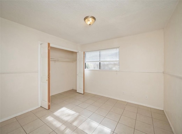 unfurnished bedroom featuring light tile patterned floors, a closet, and a textured ceiling