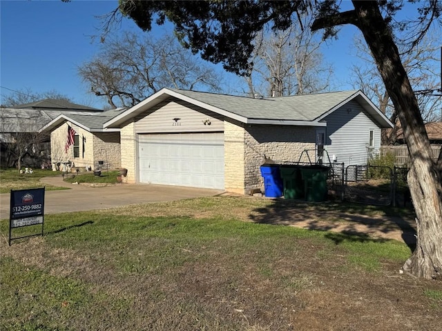 view of side of property featuring driveway, a garage, fence, and a yard