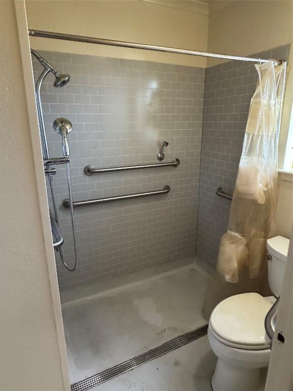 full bath featuring toilet and a shower stall