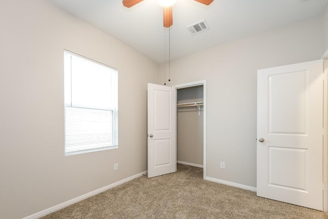 unfurnished bedroom featuring light colored carpet, a closet, and ceiling fan