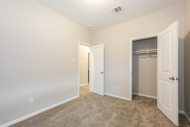 unfurnished bedroom with a closet and light carpet