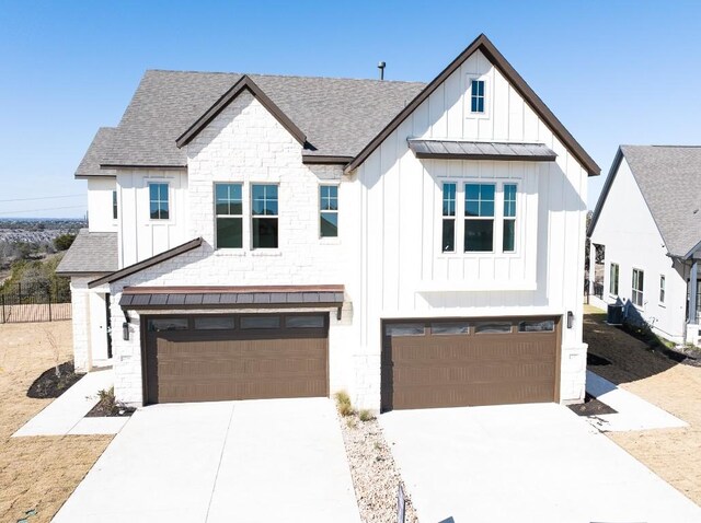 232 Flora Springs Cv, Liberty Hill, TX 78642 - modern farmhouse style home featuring an attached garage, board and batten siding, a shingled roof, and driveway