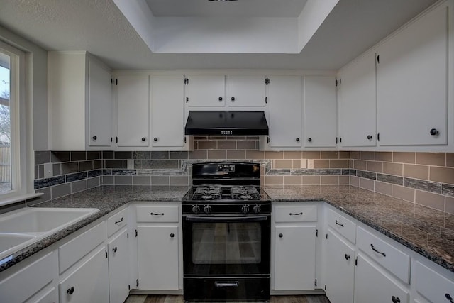 kitchen featuring white cabinetry, backsplash, custom exhaust hood, and black gas stove