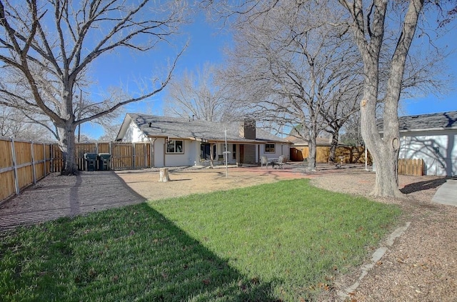 rear view of property with a yard and a patio area