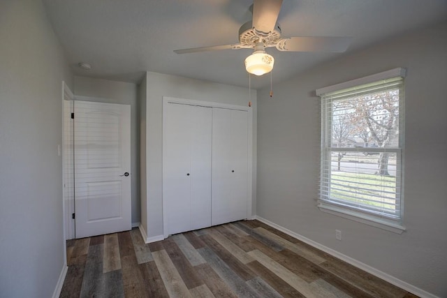 unfurnished bedroom featuring dark hardwood / wood-style flooring, a closet, and ceiling fan