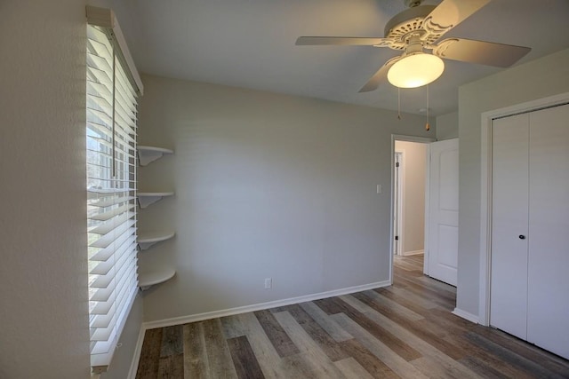 unfurnished bedroom featuring hardwood / wood-style floors, ceiling fan, and a closet