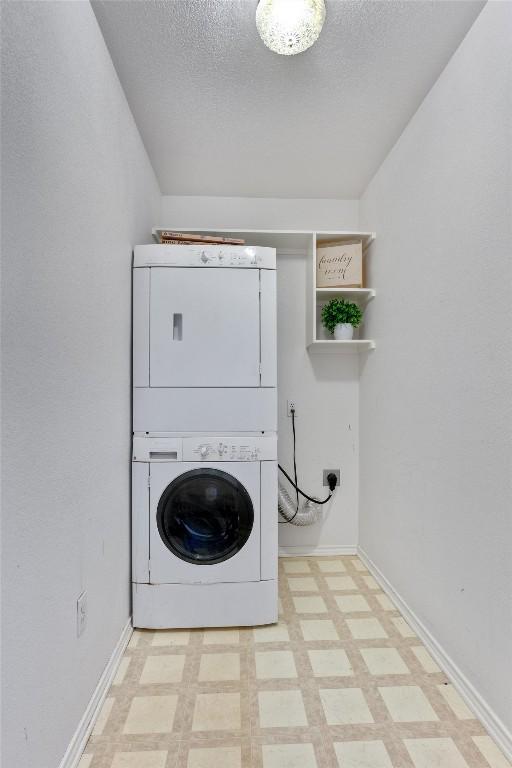 laundry room featuring stacked washer and clothes dryer and a textured ceiling