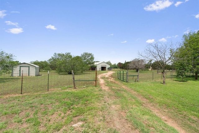 view of yard with an outdoor structure and a rural view