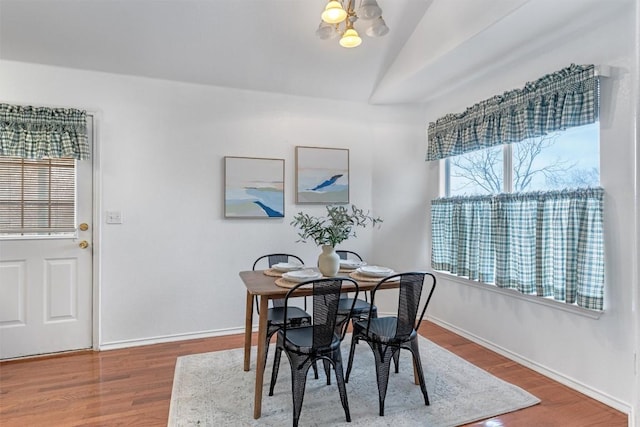 dining space with wood-type flooring and lofted ceiling