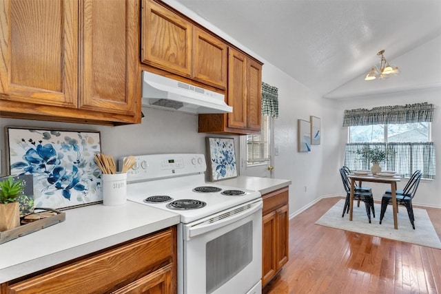 kitchen with white electric range oven, a chandelier, vaulted ceiling, and light wood-type flooring