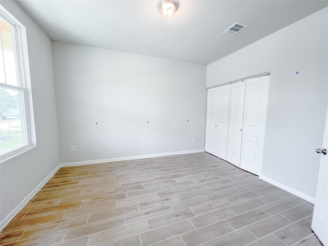 unfurnished bedroom featuring light hardwood / wood-style floors and a closet