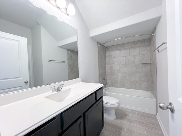 full bathroom featuring tiled shower / bath, vanity, and toilet