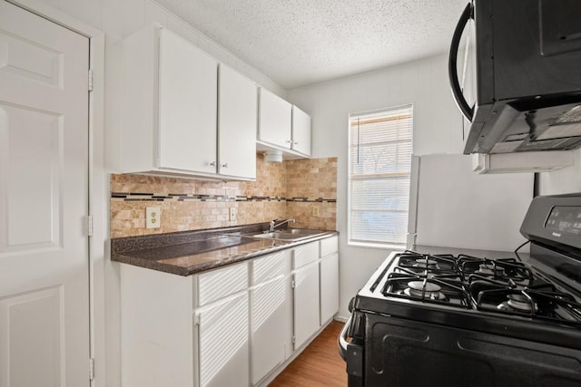 kitchen with sink, white cabinets, backsplash, black appliances, and a textured ceiling