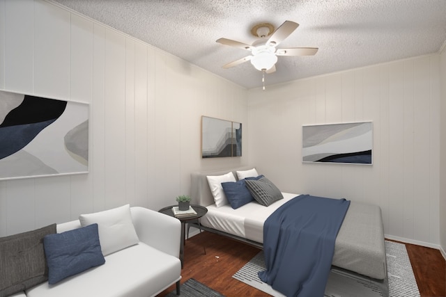 bedroom with ceiling fan, dark hardwood / wood-style floors, and a textured ceiling