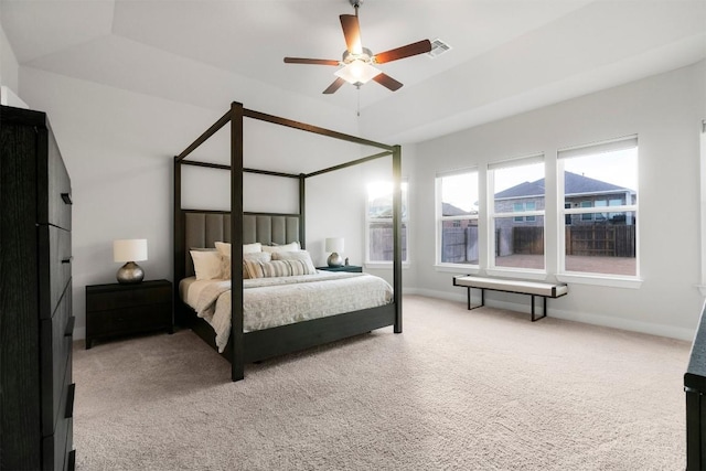 bedroom with a ceiling fan, visible vents, baseboards, carpet, and a raised ceiling