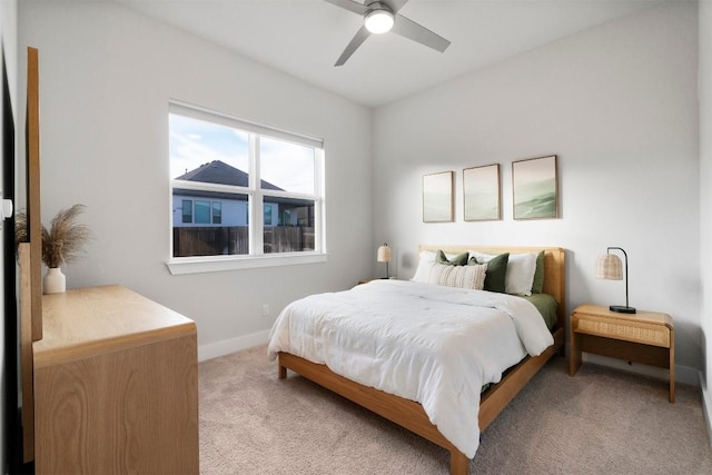 bedroom with baseboards, a ceiling fan, and light colored carpet