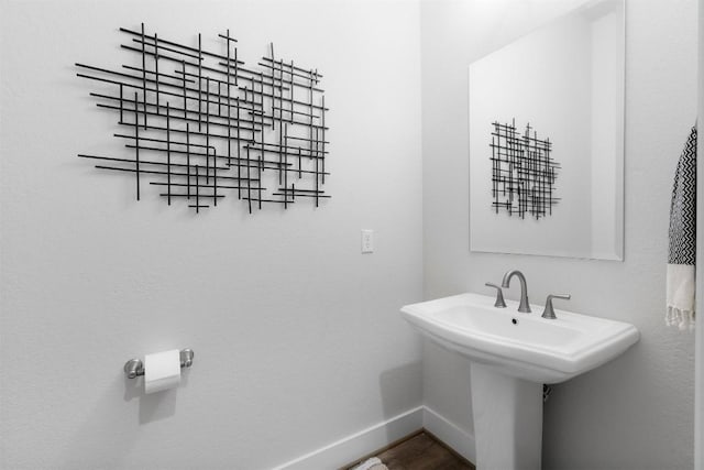 bathroom featuring a sink, wood finished floors, and baseboards