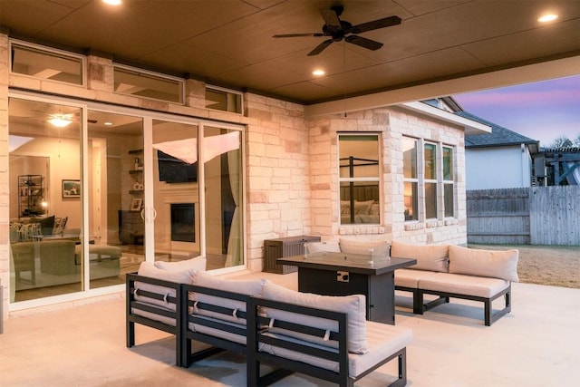 view of patio / terrace featuring ceiling fan, an outdoor living space with a fireplace, and fence