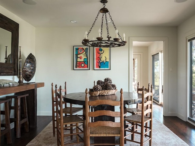 dining area featuring dark hardwood / wood-style flooring and a notable chandelier