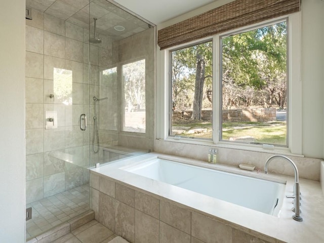 bathroom featuring a wealth of natural light and independent shower and bath