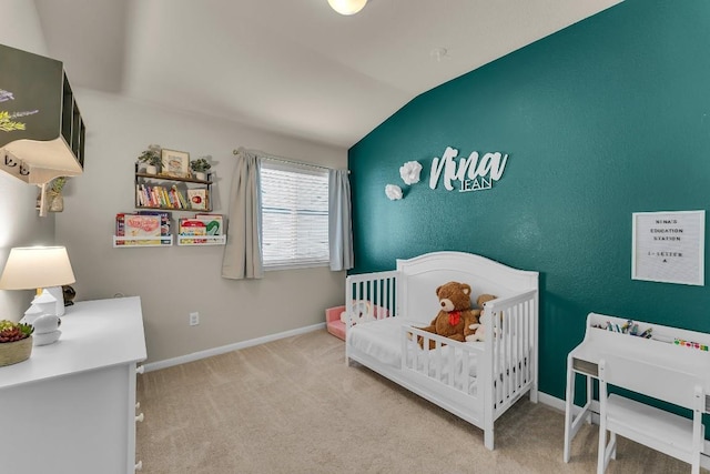 bedroom with lofted ceiling, carpet, and a crib