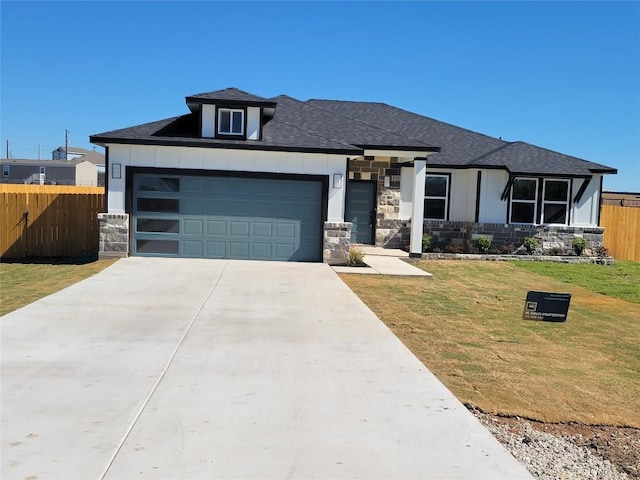 view of front of property with a garage and a front lawn