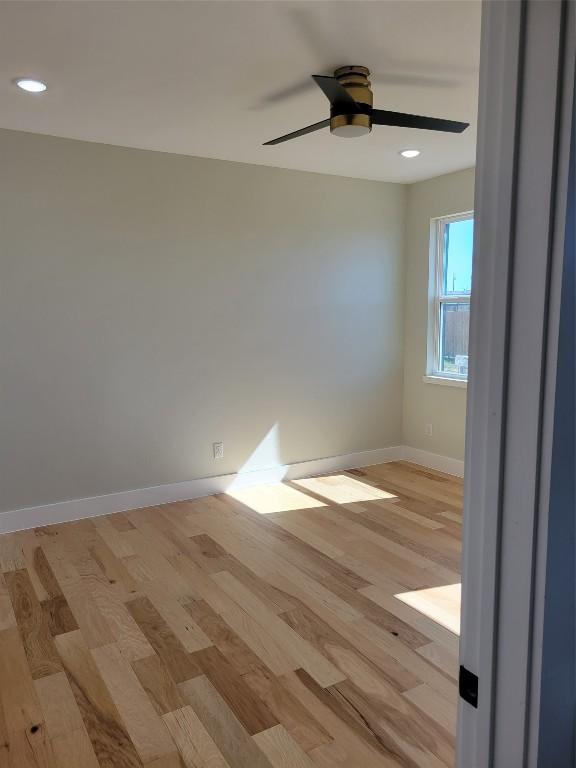 unfurnished room with ceiling fan and light wood-type flooring